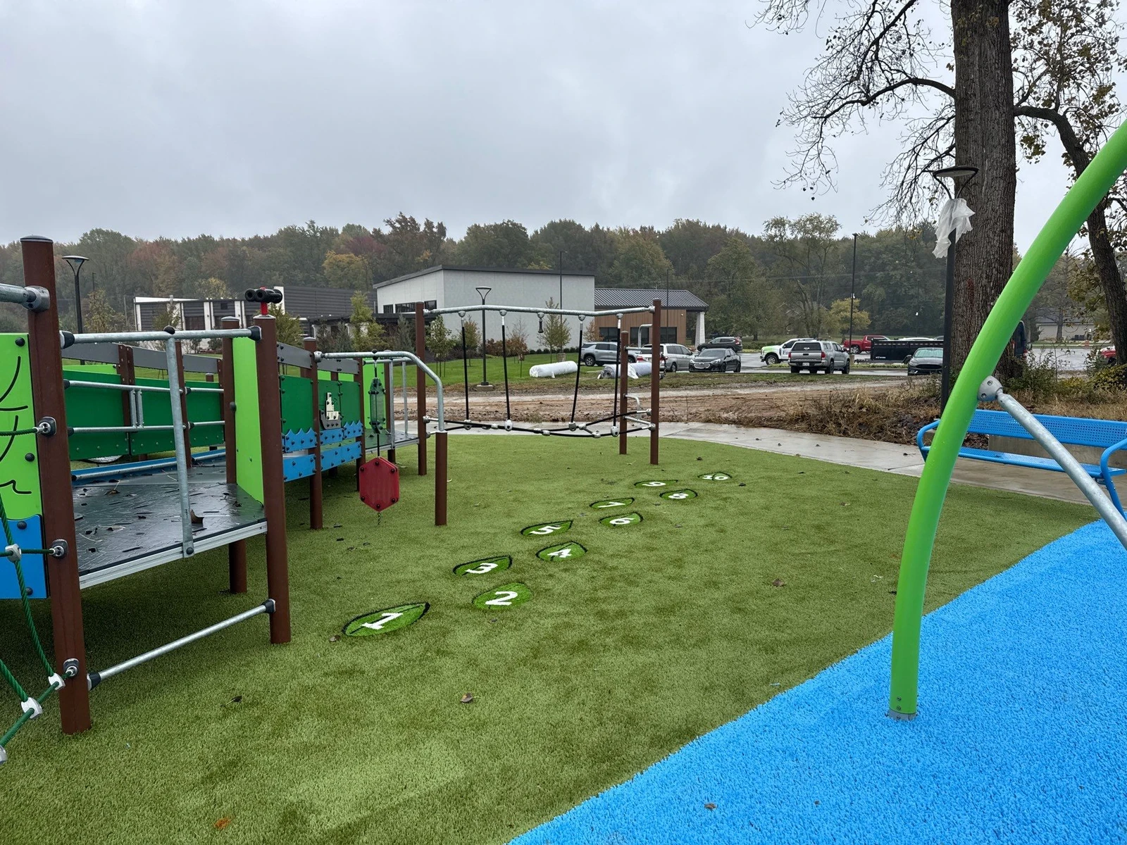 ForeverLawn Playground Grass installation at Ohio Township park with numbered stepping stones, climbing structures, and blue safety surfacing.